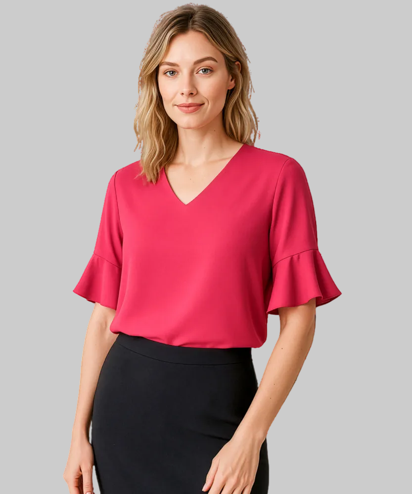 Woman wearing a pink blouse with ruffled sleeves on a white background